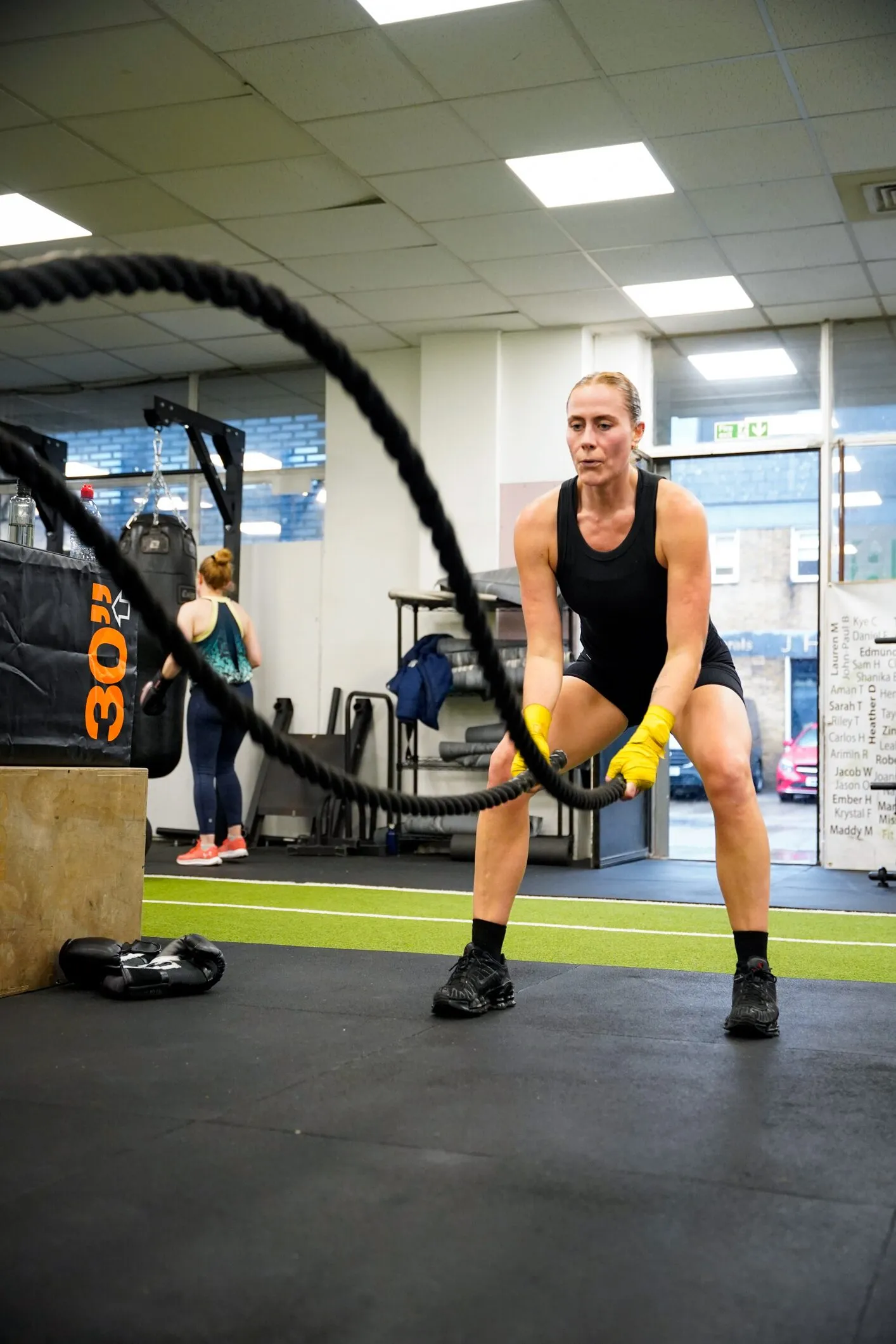 Member training with battle ropes on the gym floor at FFLY Boxing Club